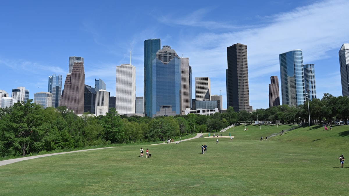 The Houston, Texas skyline seen across an open green park on a clear day